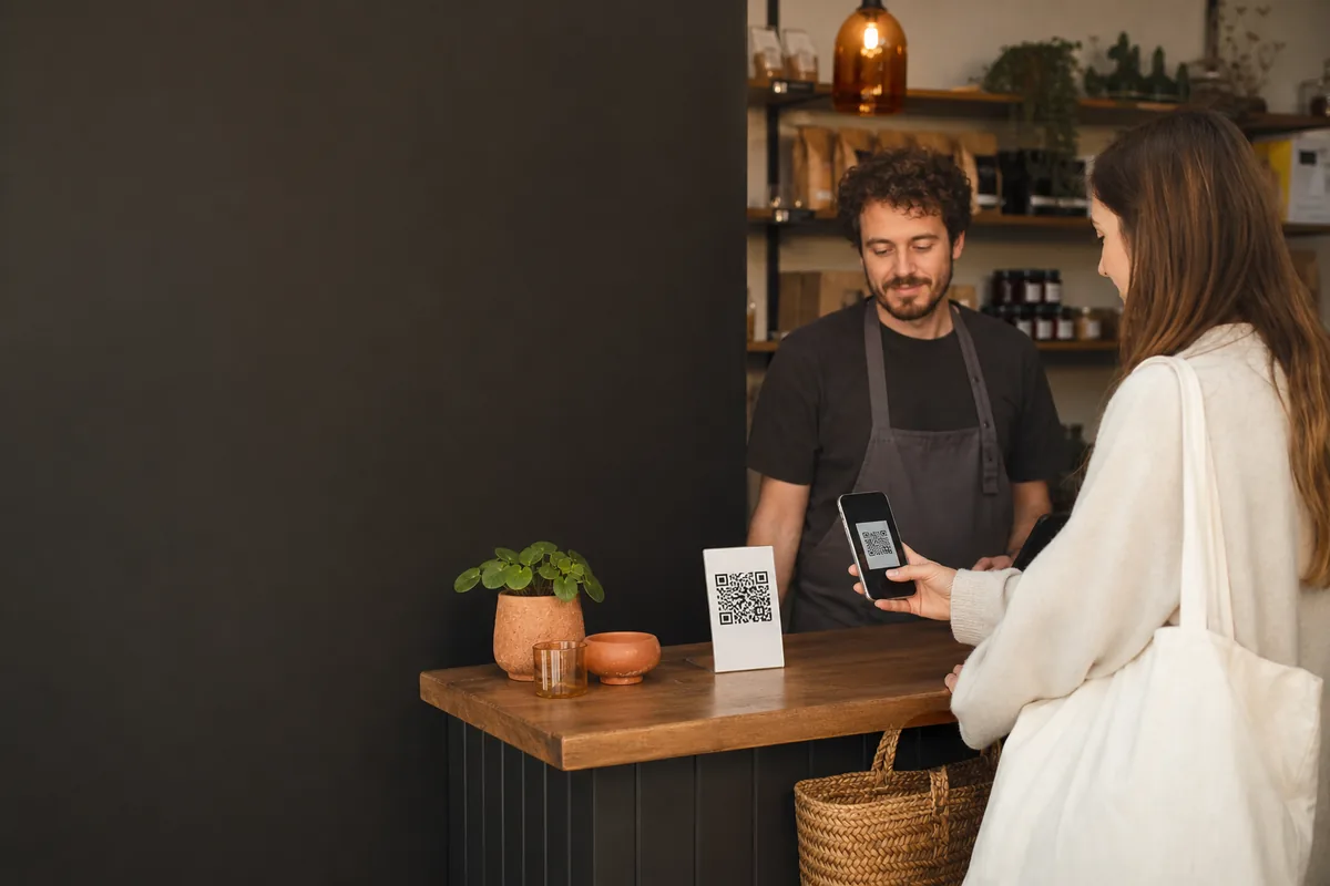 Clienta escaneando un código QR en el mostrador de un comercio
